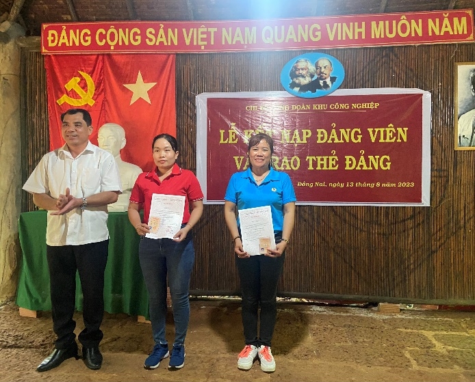 A group of people standing in front of a bannerDescription automatically generated