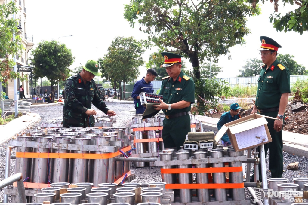 Thượng tá Phạm Minh Trí và đoàn kiểm tra khu vực đấu nối hệ thống pháo hoa tầm cao sẽ bắn chào mừng lễ. Ảnh: Nguyệt Hà