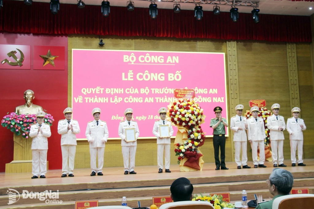 Đại tướng Lương Tam Quang, Ủy viên Bộ Chính trị, Bí thư Đảng ủy Công an Trung ương, Bộ trưởng Bộ Công an trao quyết định và tặng hoa chúc mừng Ban Giám đốc Công an thành phố Đồng Nai. Ảnh: Trần Danh