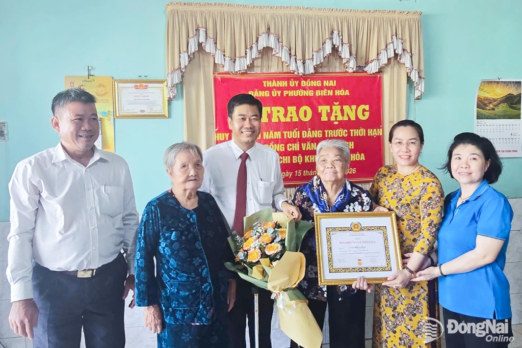 Thành ủy viên, Bí thư Đảng ủy, Chủ tịch HĐND phường Biên Hòa Viên Hồng Tiến (thứ 3 từ trái qua) đến tận nhà của đảng viên để trao tặng Huy hiệu 70 năm tuổi Đảng (trước thời hạn) cho đảng viên Văn Thị Chích, sinh hoạt Đảng tại Chi bộ khu phố An Hòa, Đảng bộ phường Biên Hòa. Ảnh: Phương Hằng