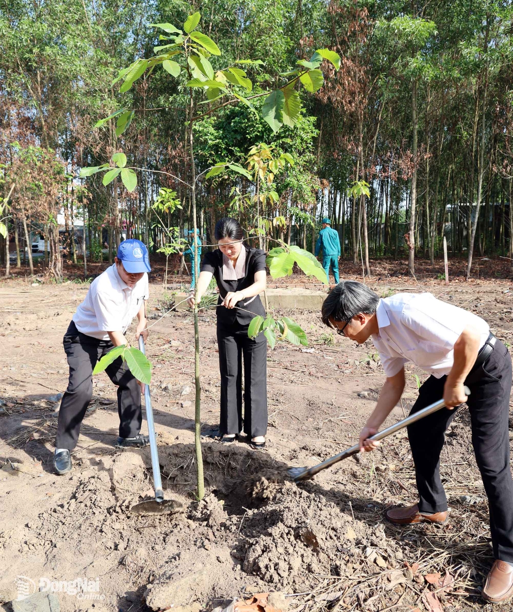 Lãnh đạo xã hưởng ứng tham gia trồng cây. Ảnh: Thu Bồn