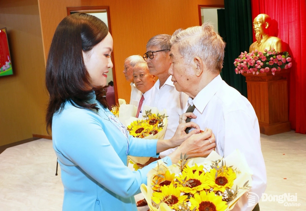 Ủy viên Ban Thường vụ Thành ủy, Bí thư Đảng ủy, Chủ tịch HĐND phường Bình Phước Giang Thị Phương Hạnh trao Huy hiệu Đảng cho các đảng viên cao tuổi Đảng. Ảnh: Trâm Tín