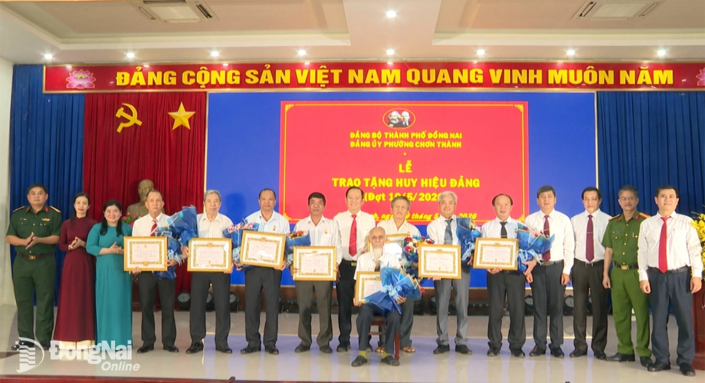 Lãnh đạo phường Chơn Thành trao Huy hiệu Đảng và tặng hoa chúc mừng các đảng viên được nhận Huy hiệu Đảng đợt 19-5. Ảnh: Đỗ Trình