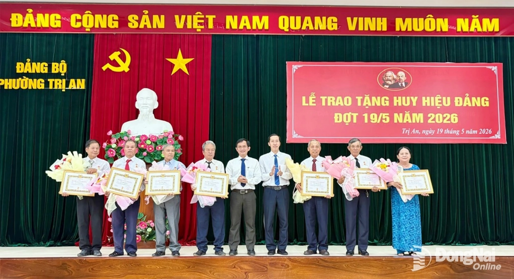 Lãnh đạo Đảng ủy phường Trị An tặng hoa chúc mừng các đảng viên được trao Huy hiệu đảng dịp 19-5. Ảnh: Quang Huy